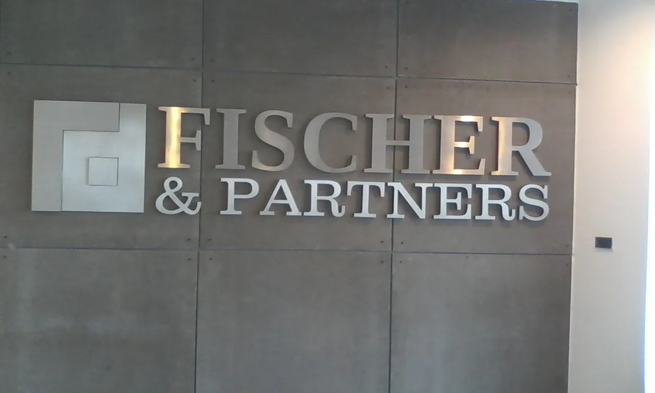 ตัวอักษรนูนสแตนเลส Fischer & Partners ติดผนังสีเทา 01