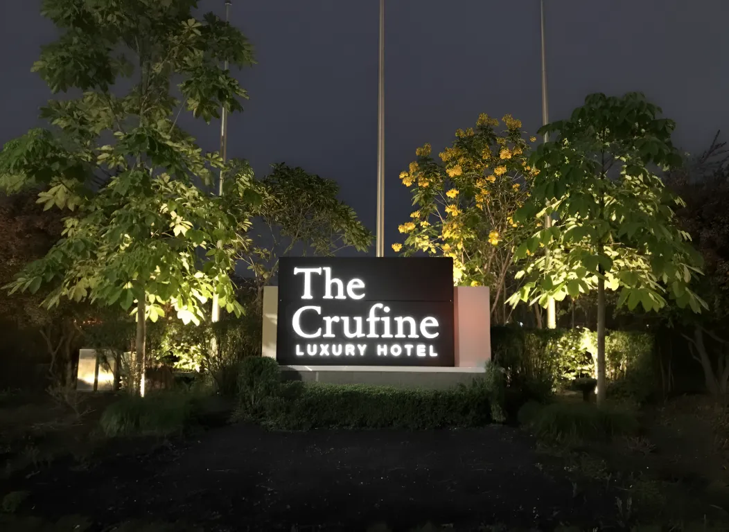 ป้ายหน้าโรงแรม The Crufine Luxury Hotel ส่องสว่างยามค่ำคืน