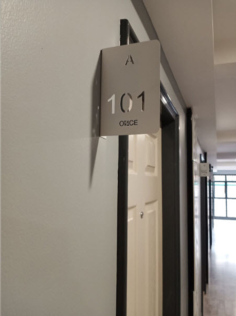 ป้ายเลขห้องสแตนเลสฉลุ A 101 OFFICE มุมกว้างแสดงทางเดินสำนักงาน