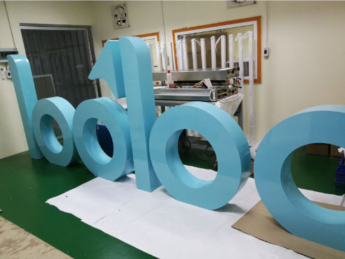 ตัวอักษรสามมิติสีฟ้าอ่อน lodloc วางบนพื้นโรงงานผลิตป้าย