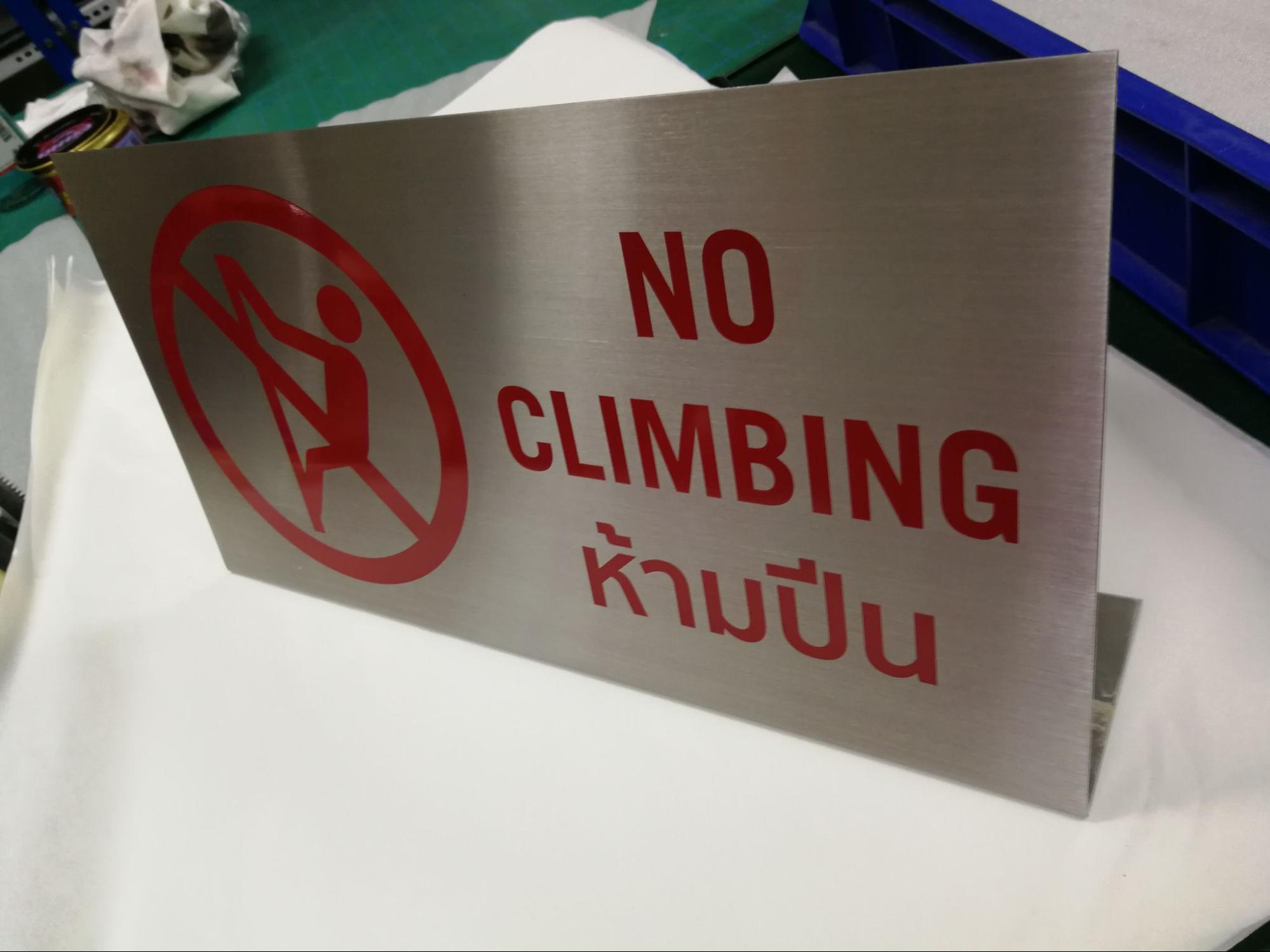 ป้ายห้ามปีน NO CLIMBING วัสดุสเตนเลส ตัวอักษรสีแดงพร้อมสัญลักษณ์ห้ามปีน ข้อความสองภาษาไทย-อังกฤษ