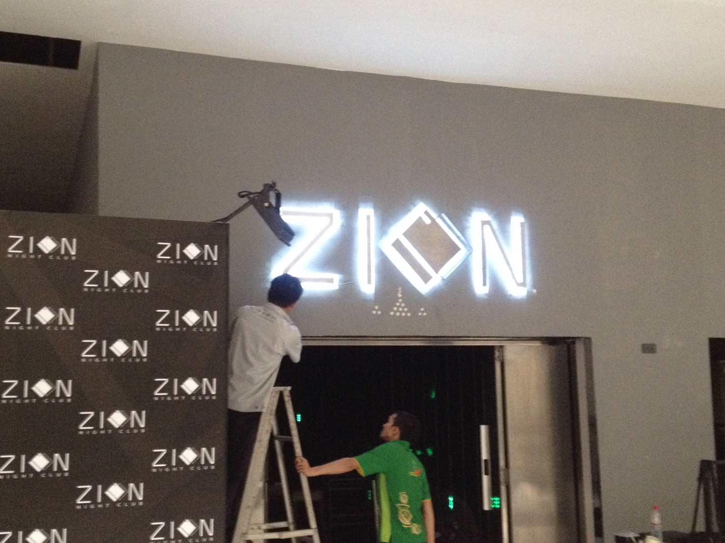 ป้ายไฟ LED สีขาว ZION กำลังติดตั้งโดยช่างบนบันได