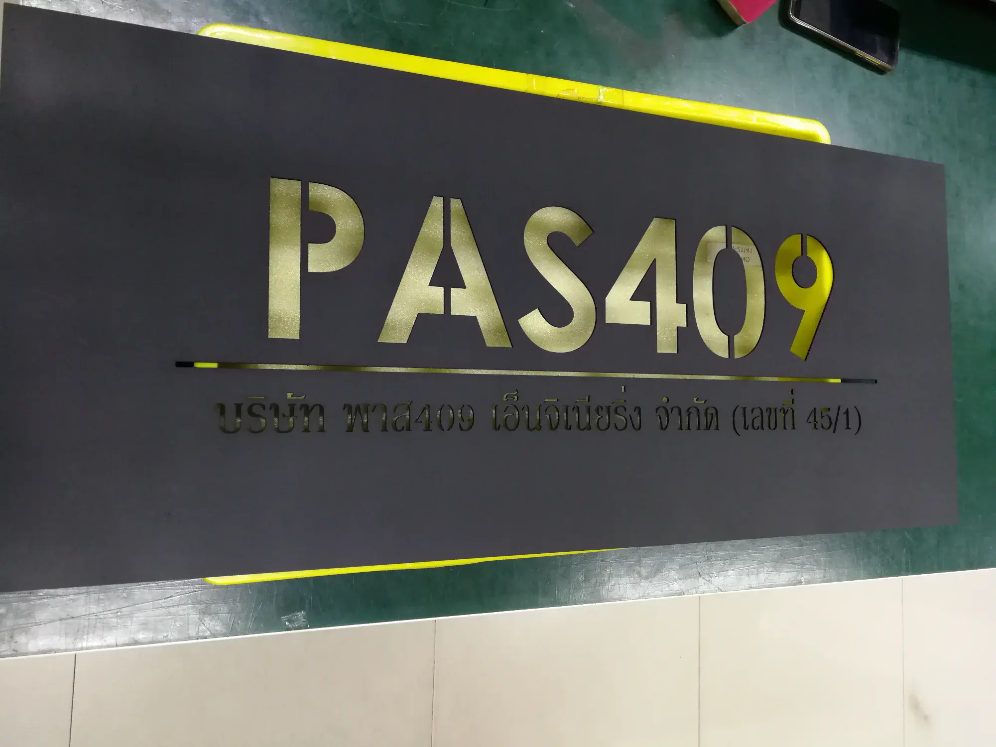 ป้ายสแตนเลสสีทอง PAS409 บริษัท พาส409 เอ็นจิเนียริ่ง จำกัด บนพื้นดำ