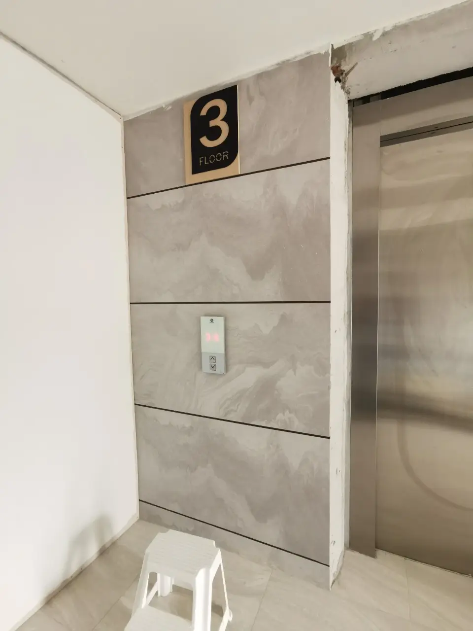 ป้ายบอกชั้น 3 FLOOR สีดำตัวอักษรครีม ติดตั้งข้างลิฟต์บนผนังหินอ่อน