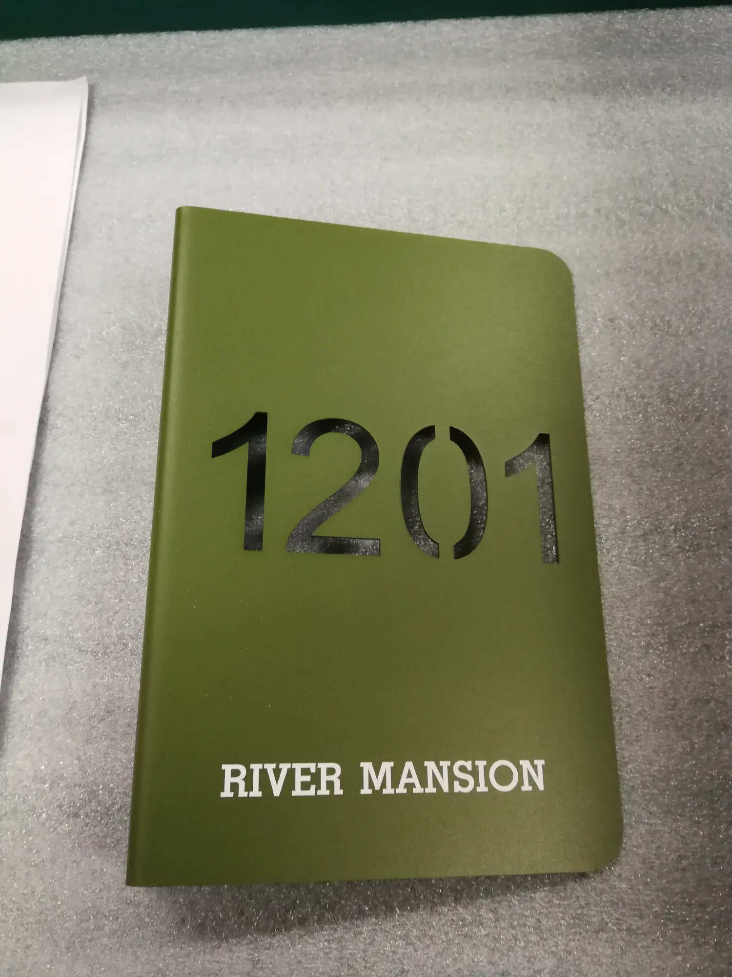 ป้ายหมายเลขห้อง 1201 อลูมิเนียมสีเขียวมะกอก พร้อมชื่อ River Mansion ตัวอักษรสีขาว