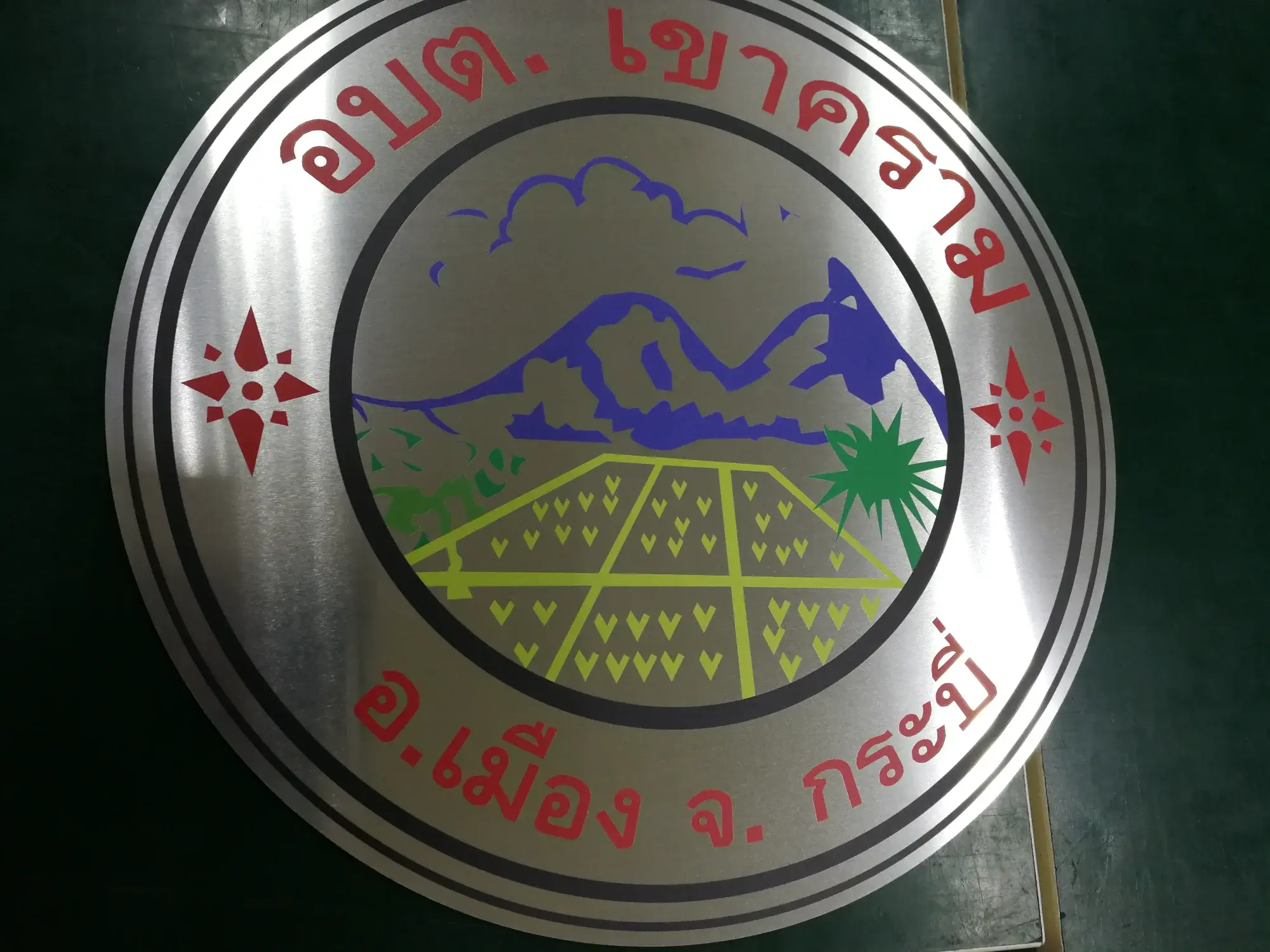 ป้ายตราสัญลักษณ์ อบต.เขาคราม อ.เมือง จ.กระบี่ สแตนเลส รูปภูเขาน้ำเงินและทุ่งนาลายหัวใจ