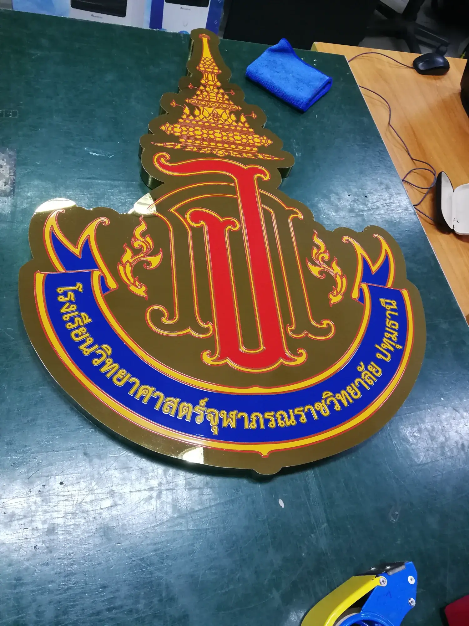 ป้ายตราสัญลักษณ์โรงเรียนวิทยาศาสตร์จุฬาภรณราชวิทยาลัย ปทุมธานี รูปอักษร ภ ทองใต้มงกุฎ