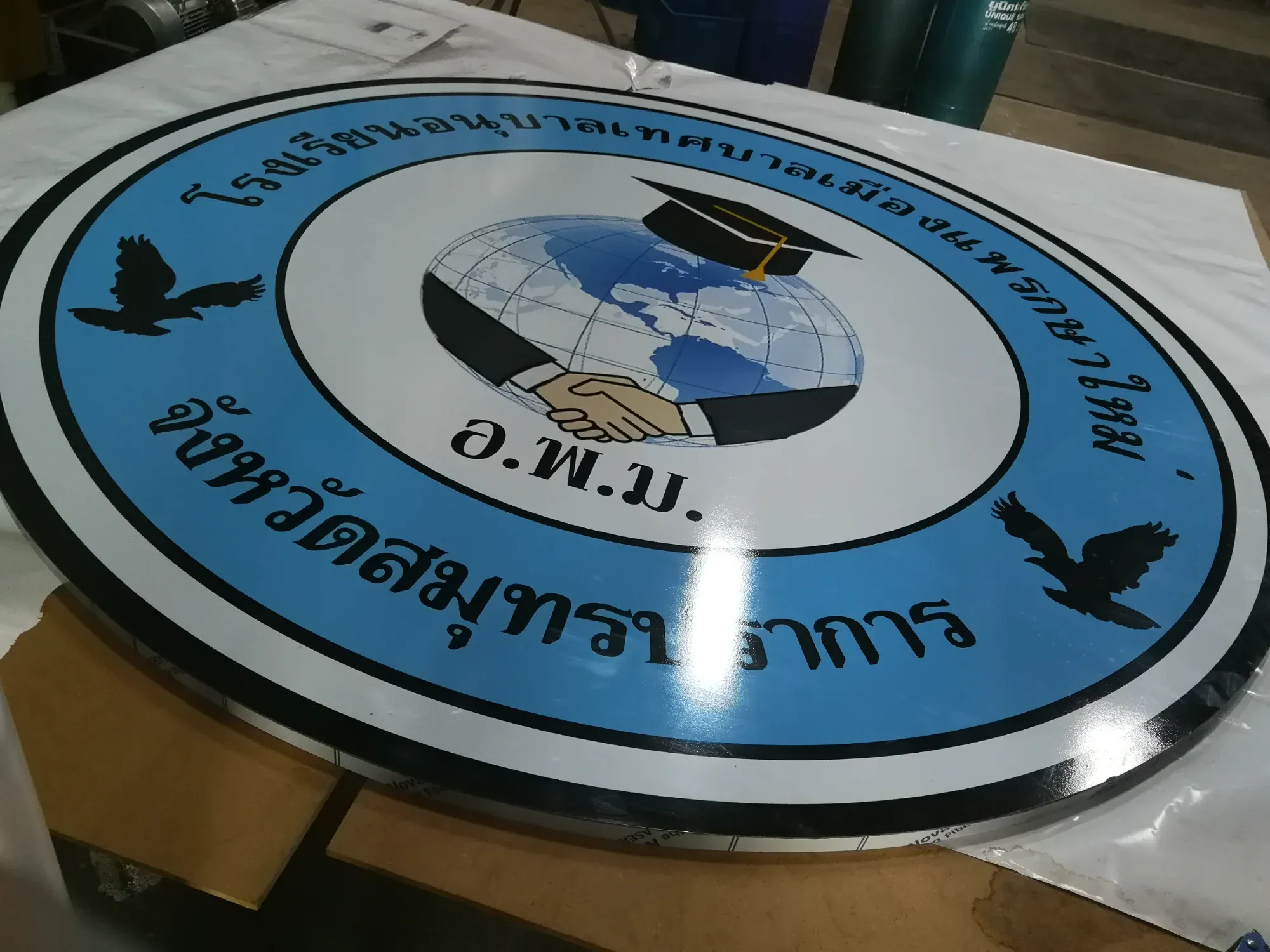 ป้ายตราสัญลักษณ์โรงเรียนอนุบาลเทศบาลประกาศ สแตนเลส รูปลูกโลกพร้อมหมวกบัณฑิตและมือจับมือ